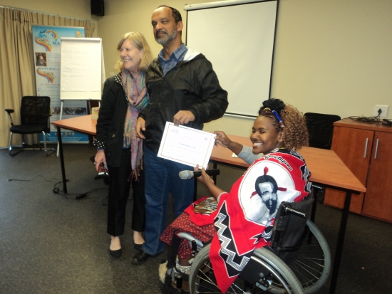 Moosa Salie is receiving a certificate from Bongiwe Malope, while Marcia Rioux is standing next to them. 