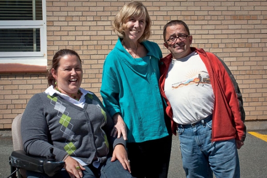 Susan Ralph, Marcia Rioux and Steve Estey pose outside with a yellow brick building in the background.