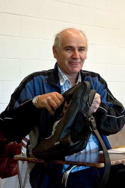 Brian Conway seated at a desk in front of a cream-coloured brick wall.