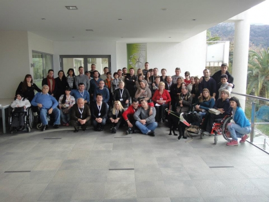 Participants gather outside on a balcony to have their photo taken as a group. 