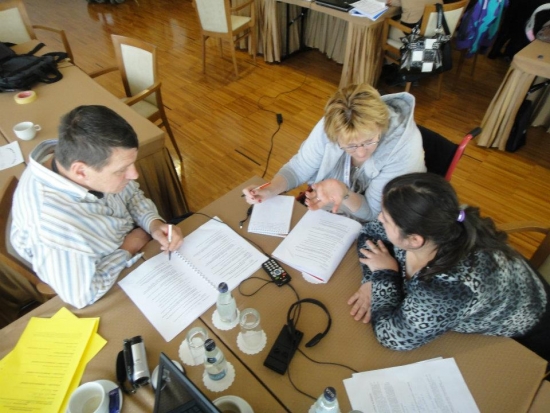 Pictured sitting around a table are three participants practicing individual monitoring techniques. The photo is taken from above. 