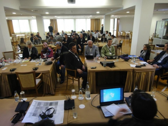 A photo of the training room, taken from the front of the room looking towards the back everyone is seated and listening to the presentation. 