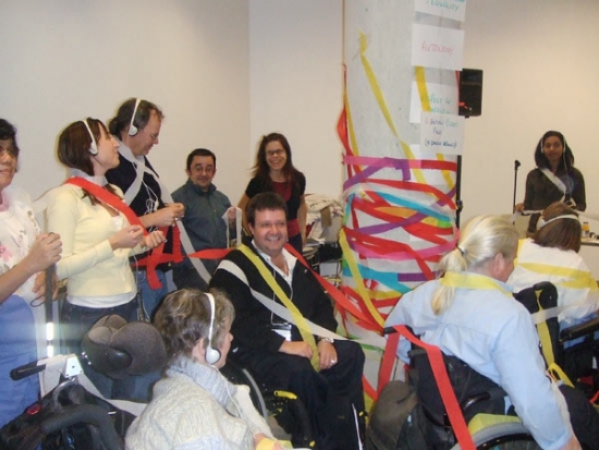 Celebration photo at the end of the training, participants are covered in streamers and there is a large pole in the middle of the photo which is covered as well.