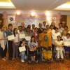 Participants, interpreters & facilitators pose together with their certificates and smile. 