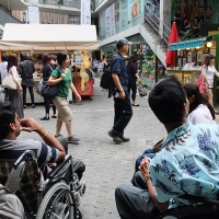 <p>
	The Indian participants (sitting in a wheelchair) in the market are about to do shopping.</p>
