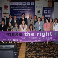 Group photo after the workshop with the  Korean Federation of the Disabled (KOFOD), holding a large sign with the slogan "make the right real"