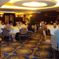 Marcia Rioux stands to the left while speaking to the seated participants. 