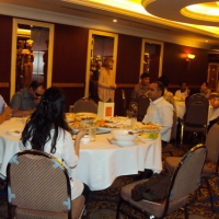 Marcia Rioux stands and welcomes the seated participants. 