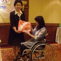 Ms. Kingkaew Inwang smiles while being given a token of gratitude by Ms. Saowalak Thongkuay.