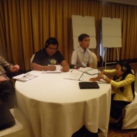 Participants sit around a large round table.