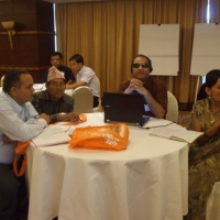 Participants sit around a large round table. 