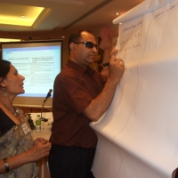 Birendra Raj Pokharel of Nepal writes his group's ideas on a flip chart during the training, while Ram Pyari Karki stands behind him. 