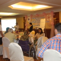 Mr. Soy and Ms. Channtey stand at the front of the room and present to seated participants in the foreground.