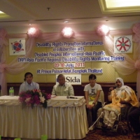 MD Rasel, Ashrafun, Channtey, Lauro, Lapkeo and Roosevelt sit behind a table. Lapkeo speaks into a microphone.