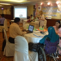 Roosevelt, MD Rasel, Ashrafun and Farhana sit at a table and work with training materials.