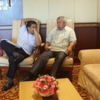 Lauro Purcil and Rannil Sorongon recline in comfortable chairs and talk. 