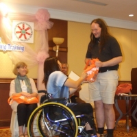 Saowalak Thongkuay gives Nathan Bond an orange bag while other facilitators look on.