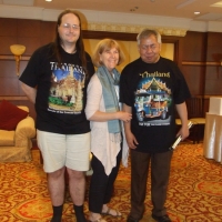 Nathan Bond, Marcia Rioux and Lauro Purcil stand together and smile for a picture inside the hotel. 