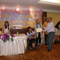 Harka Bahadur Bam holds his certificate with Saowalak Thonkuay while other facilitators look on. 