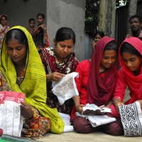 <p>Four women entrepreneurs from a local DPO seated working on sewing crafts</p>
