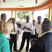 Marcia Rioux and Oswald Tuyizere are in the foreground talking to a group of hotel staff.