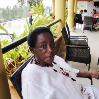 A woman reclines in a chair on a veranda.