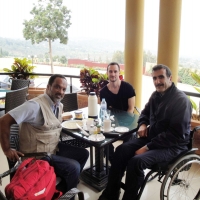 Mohamed El Khadiry (right), Chris Lytle (centre) and Moosa Salie sit at a table on a veranda overlooking the local country side.