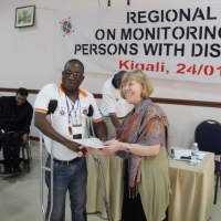 Robert Mkozho shakes hands with Marcia Rioux, who is giving him a certificate