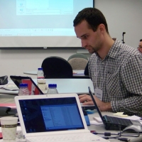 Chris Lytle is sitting a table crowded with laptops, water bottles and papers.