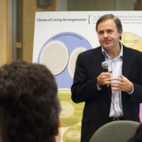 Andrew Laing stands while speaking to the meeting participants