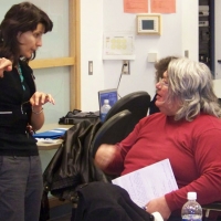 Miha Dinca stands and gestures while speaking with Patrick Fougeyrollas.