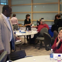 Numerous participants are conversing in small groups throughout the room.