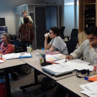 <p>
	Sandra Carpenter is to the left of the frame as she glances towards the camera. Other people in the frame are taking a sip of coffee, studying or having discussions.</p>
