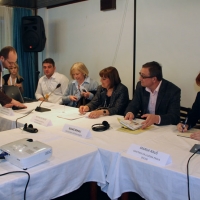 <p>
	Zoltan Mihok is explaining something to the organizational representatives who are all seated behind a long rectangular table with a white tablecloth.</p>
