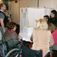 Participants gather around a table with an election box on it.