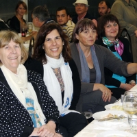 Marcia Rioux, Ljiljana Igrić and Paula Pinto are seated at a long dinner table and smiling.