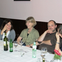 <p>
	Chris Lytle, Paula Pinto, Marcia Rioux, Zoltan Mihok and Ann Marit Saebones sit and laugh next to each other at a long table with wine bottles, water bottles and wine glasses.</p>
