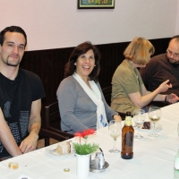 Chris Lytle, Paula Pinto, Marcia Rioux and Zoltan Mihok are seated at a long dinner table. Marica talks with Zoltan while Chris and Paula smile for the picture.