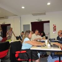 <p>
	Photo of the training room with groups seated at tables working.</p>
