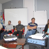 Jose Leal, Germán Sciurano, Guillermo Pinilla, Ronaldo Bacry and Carolina Buceta, Carolina speaks into the microphone. All participants are seated and there are flip charts behind them. 