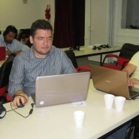 Ronaldo Bacry and Alexandre Mapurunga are seated at a table and are looking at their computers. 