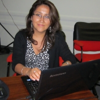 <p>
	Ana Lucia Arellano working during training session. She is seated at a table behind her computer.</p>
