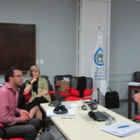 Jose Leal signing during the training; the sign language interpreter is interpreting; Marcia Rioux is at the back listening.