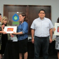 Marcia Rioux, Verónica González, Jose Viera, Ana Lucia Arellano and Paula Pinto during closing ceremony. Paula is handing a frame with an Canadian aboriginal painting to Verónica. Ana Lucia is showing the painting she received and her diploma. 