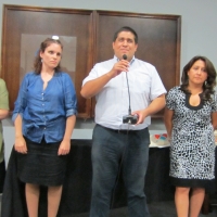 Marcia Rioux, Verónica González, Jose Viera, Ana Lucia Arellano and Paula Pinto stand in a row during closing ceremony. Jose Viera is speaking to the larger group. 