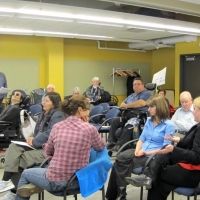 <p>
	Participants sit in the foreground while a man (Robin Loxton) stands to the side and presents.</p>
