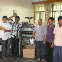 <p>Male trainees at the National Institute for the Mentally Handicapped pose on either side of a printing press</p>
