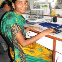 <p>A woman smiling from her desk at Rajiv Gems Park</p>
