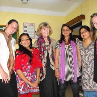 <p>Paula Hearn, Marcia Rioux and Alexis Buettgen pose indoors with women from Nepal Disabled Women&#39;s Network</p>
