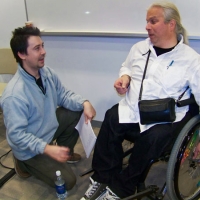 Olivier (left) and Normand (right) are having a discussion. Olivier is crouched down, facing Normand. 